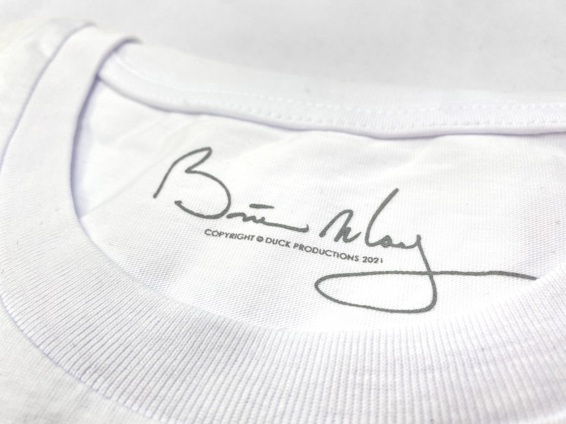 Neck print of Brian May's signiture on a printed t-shirt by Paul Bristow